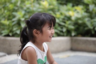 Cute girl smiling against trees