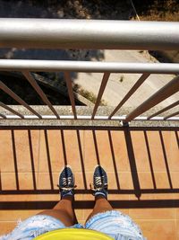 Low section of man standing on railing