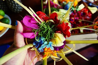 Close-up of hand holding bouquet of flowering plant