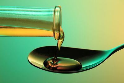 Close up of oil pouring on spoon