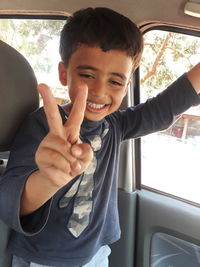 Portrait of boy gesturing in car