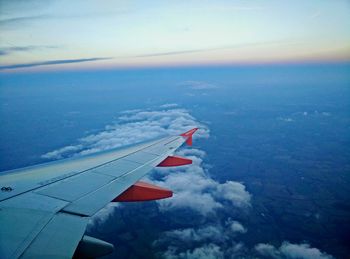 Cropped image of airplane flying over cloudscape