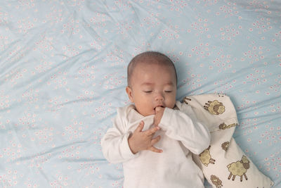 Cute baby girl lying on bed