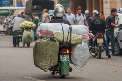 Rear view of people walking on road in city