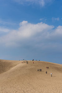 People at beach against sky