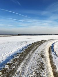 Scenic view of snowy field against sky