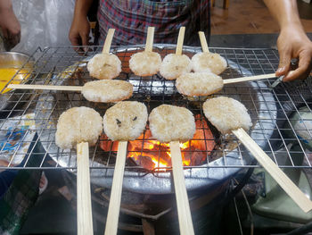 Midsection of person preparing food on barbecue grill