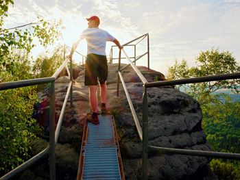 Rear view of man walking on staircase