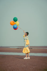 Full length of a girl holding balloons