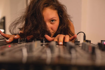 Close-up of fashionable young woman playing music at home