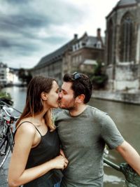 Young couple kissing while standing in city