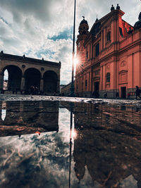 Reflection of building in puddle on street