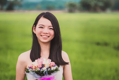 Portrait of a smiling beautiful young woman on field