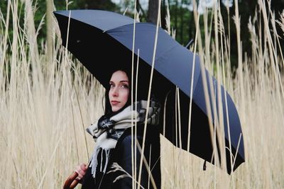 Portrait of young woman standing on field