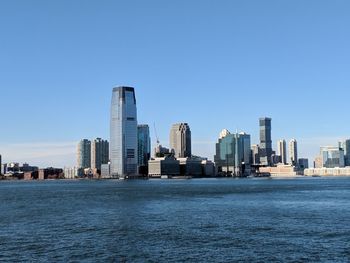 City at waterfront against blue sky