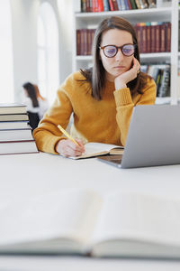 Young woman using laptop at table