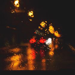 Close-up of wet illuminated road during rainy season