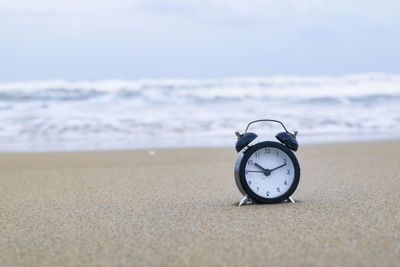 Close-up of clock on the beach