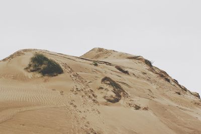 Sand dunes in desert against clear sky