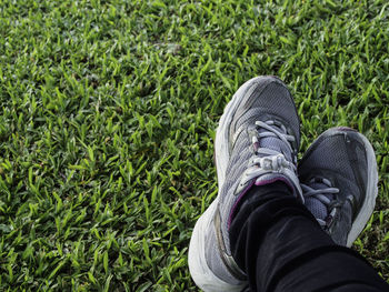 Low section of person wearing shoes on field