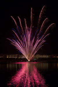 Firework display over river at night