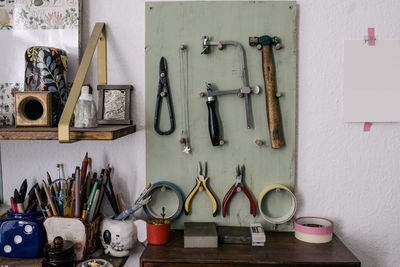 Work tools and equipment hanging on board by wall