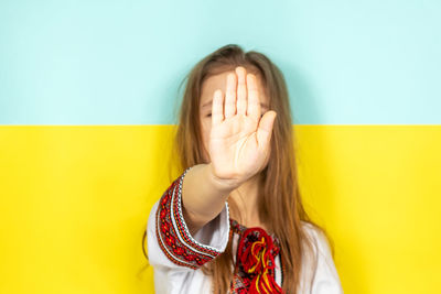 Portrait of young woman against wall