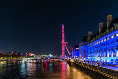 View of illuminated bridge and buildings at night