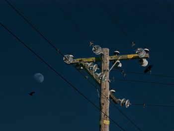 Low angle view of electricity pylon against sky