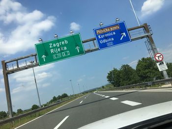 Road sign against sky