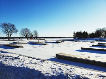 Scenic view of snow covered field against clear blue sky