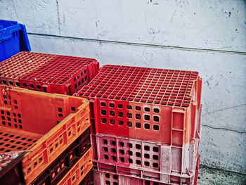 Pile of old vibrant colored plastic baskets against grungy wall