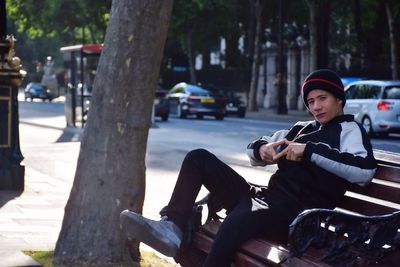 Man sitting on mobile phone in city