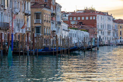 Sailboats moored on canal against buildings in city