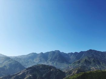 Scenic view of mountains against clear blue sky