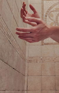 Midsection of man holding umbrella against wall