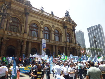 Crowd in city against sky