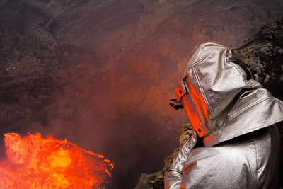 High angle view of person wearing protective workwear by volcano