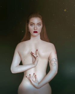 Digital composite image of topless beautiful young woman standing against black background