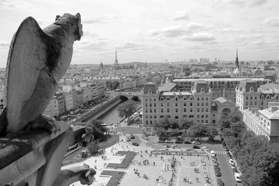 Statue in city against sky