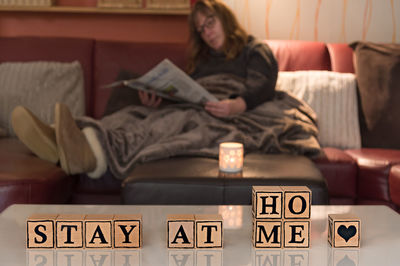Woman sitting on book at home