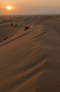 Scenic view of desert against sky during sunset