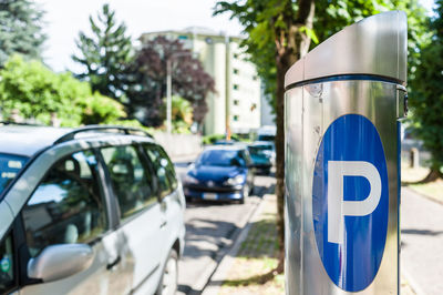 Close-up of parking sign with car in background