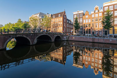 Reflections of buildings in the keizersgracht canal on a quiet summer morning in amsterdam