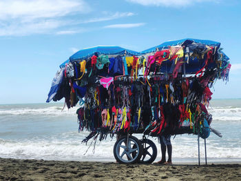 Multi colored umbrellas hanging on beach against sky