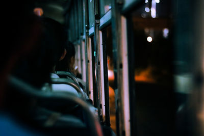 Rear view of people travelling in bus at night