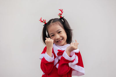 Portrait of young woman holding gift box against white background