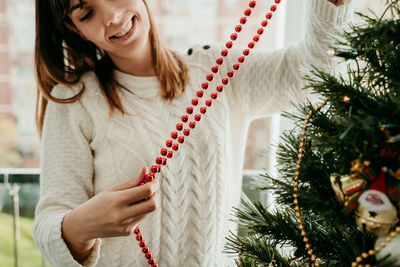 Midsection of woman with christmas tree