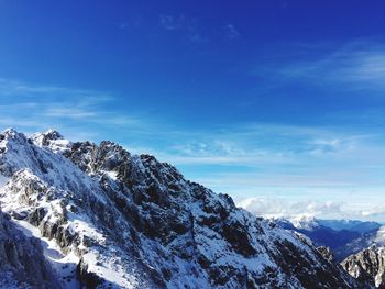 Scenic view of snowcapped mountains against blue sky