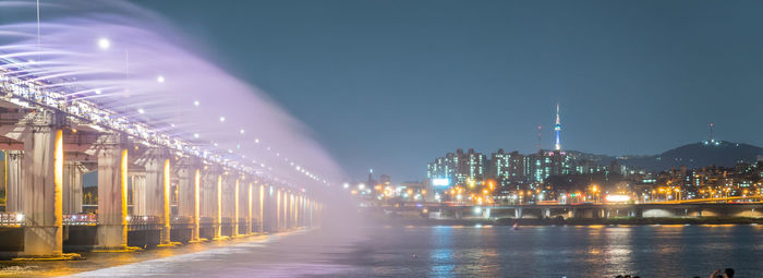 Moonlight rainbow fountain on banpo bridge over han river against clear sky at dusk